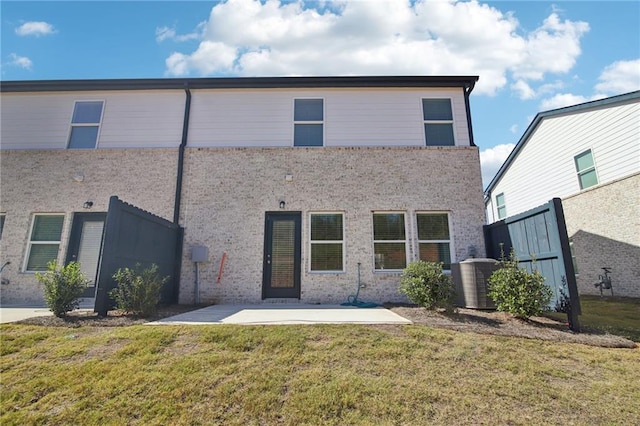 rear view of property with central AC, a lawn, and a patio area