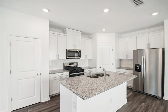 kitchen with white cabinetry, appliances with stainless steel finishes, sink, and a center island with sink