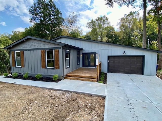 view of front of property featuring french doors, a deck, and a garage