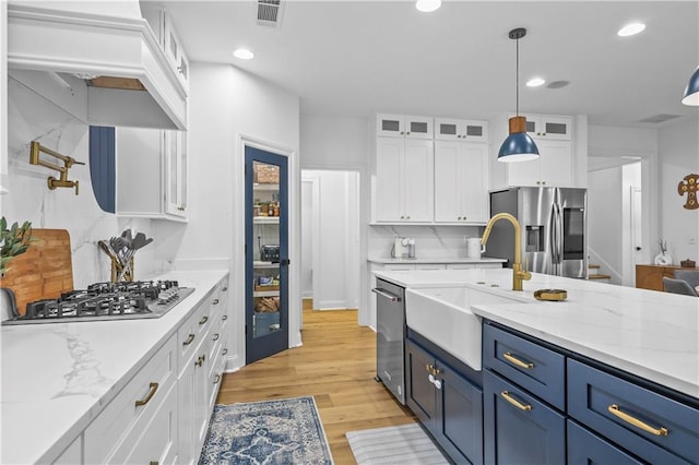 2013 White Cypress Ct, Smyrna, GA 30082 - kitchen featuring appliances with stainless steel finishes, a sink, white cabinetry, glass insert cabinets, and light wood finished floors