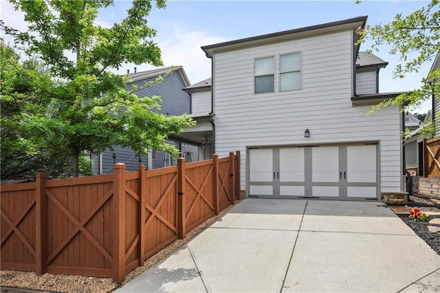 2013 White Cypress Ct, Smyrna, GA 30082 - back of house with an attached garage, a gate, and concrete driveway