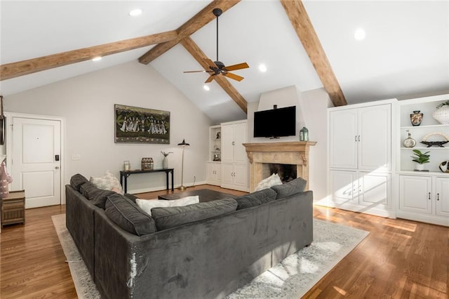 living area featuring wood finished floors, a ceiling fan, a fireplace, and recessed lighting