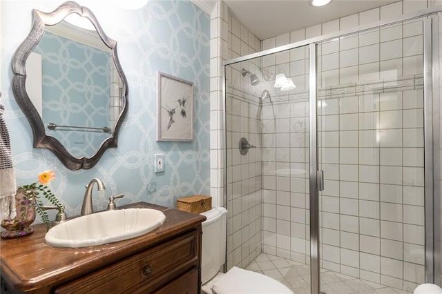 full bathroom featuring toilet, a shower stall, wallpapered walls, and vanity