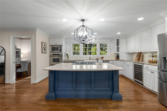 kitchen featuring wine cooler, appliances with stainless steel finishes, white cabinetry, light countertops, and a chandelier