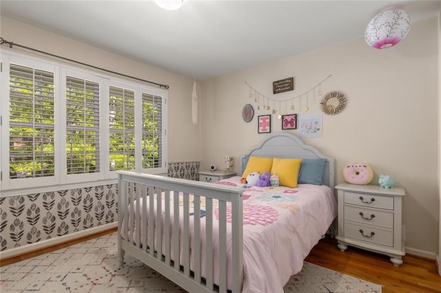 bedroom with wood finished floors and baseboards