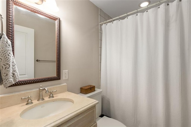 full bath featuring toilet, vanity, and curtained shower