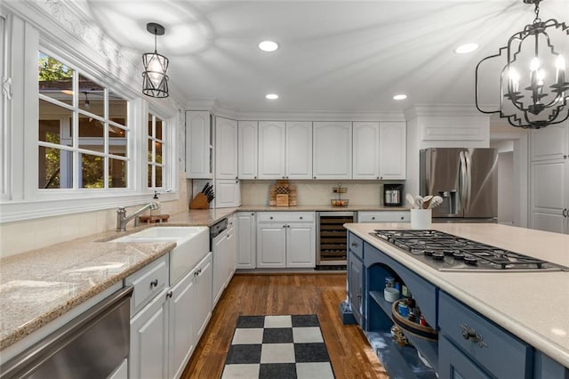 kitchen with appliances with stainless steel finishes, wine cooler, white cabinetry, a chandelier, and recessed lighting
