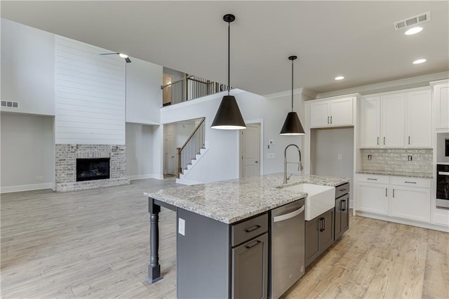 kitchen with white cabinetry, pendant lighting, and stainless steel dishwasher