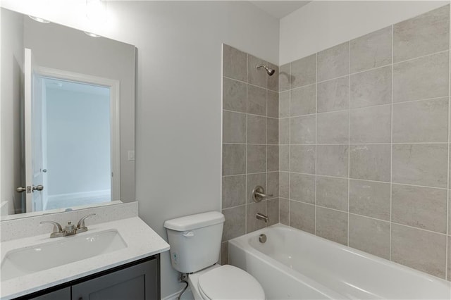 full bathroom featuring vanity, tiled shower / bath, and toilet