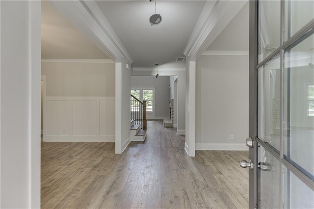 foyer entrance featuring ornamental molding and light hardwood / wood-style flooring