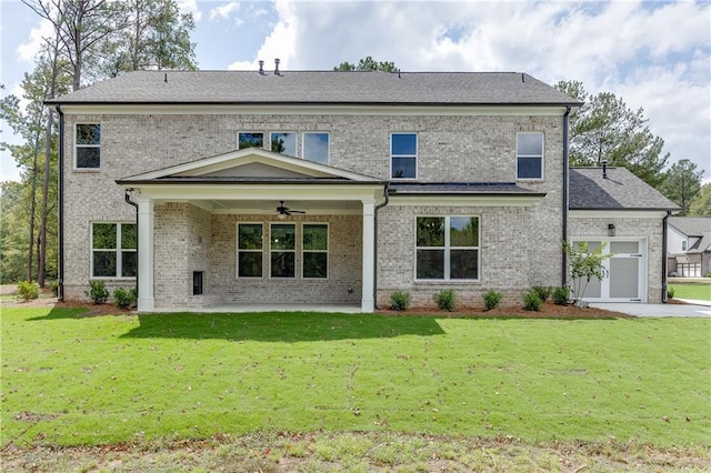 rear view of house featuring a garage, a yard, and ceiling fan