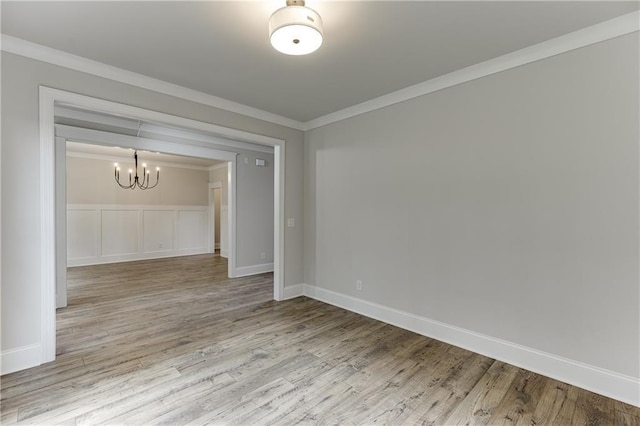 unfurnished room with hardwood / wood-style flooring, a chandelier, and ornamental molding