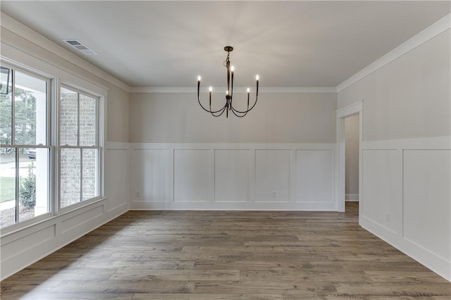 unfurnished dining area with hardwood / wood-style flooring, a notable chandelier, and a wealth of natural light