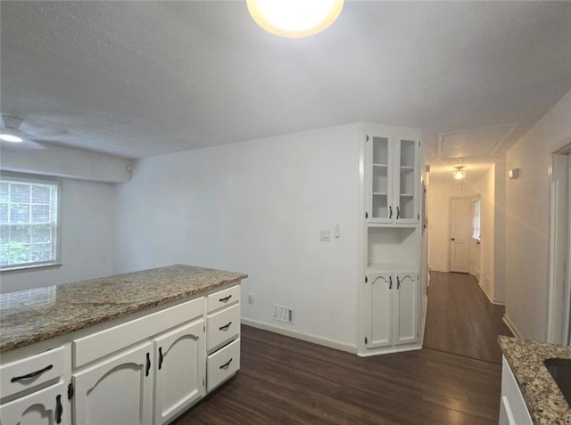 2821 NE Meadowlark Trl, Duluth, GA 30096 - kitchen with dark wood-style flooring, white cabinetry, glass insert cabinets, baseboards, and a textured ceiling