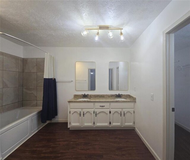 2821 NE Meadowlark Trl, Duluth, GA 30096 - full bath featuring wood finished floors, shower / bath combination with curtain, double vanity, a textured ceiling, and baseboards