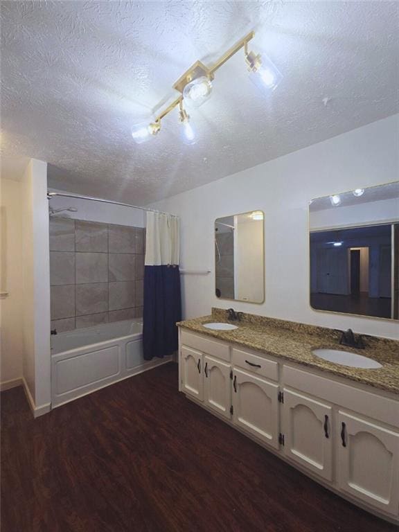 2821 NE Meadowlark Trl, Duluth, GA 30096 - full bathroom with a textured ceiling, wood finished floors, double vanity, and shower / bath combo with shower curtain