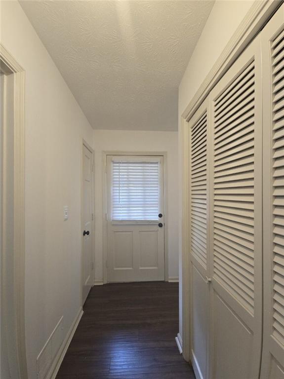 2821 NE Meadowlark Trl, Duluth, GA 30096 - hallway featuring dark wood-style flooring, baseboards, and a textured ceiling