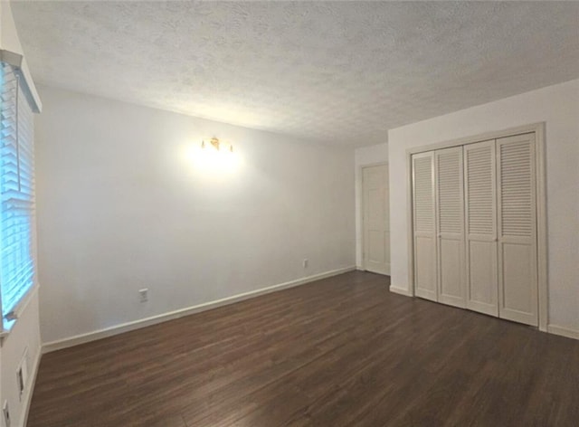 2821 NE Meadowlark Trl, Duluth, GA 30096 - unfurnished bedroom with dark wood-type flooring, baseboards, a textured ceiling, and a closet