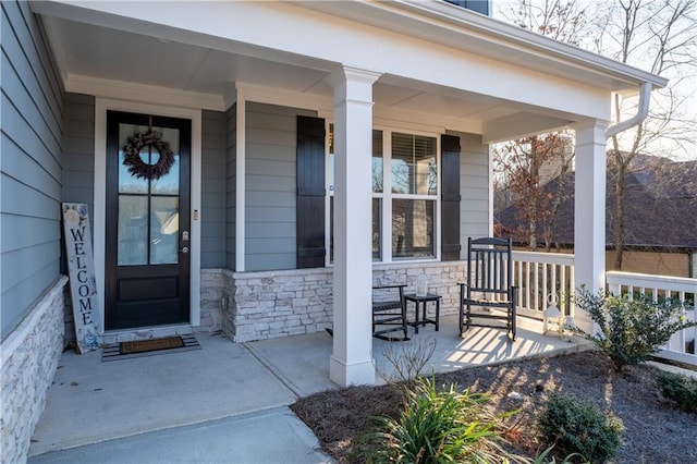 doorway to property featuring stone siding and a porch