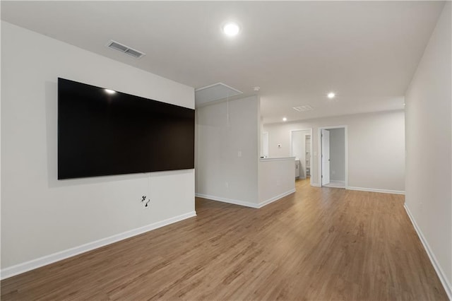 unfurnished room featuring attic access, visible vents, recessed lighting, light wood-style flooring, and baseboards