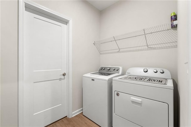 laundry area featuring laundry area, light wood-style flooring, baseboards, and separate washer and dryer
