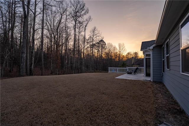 yard at dusk featuring a patio