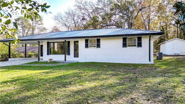 ranch-style home featuring a carport, a front yard, and central AC