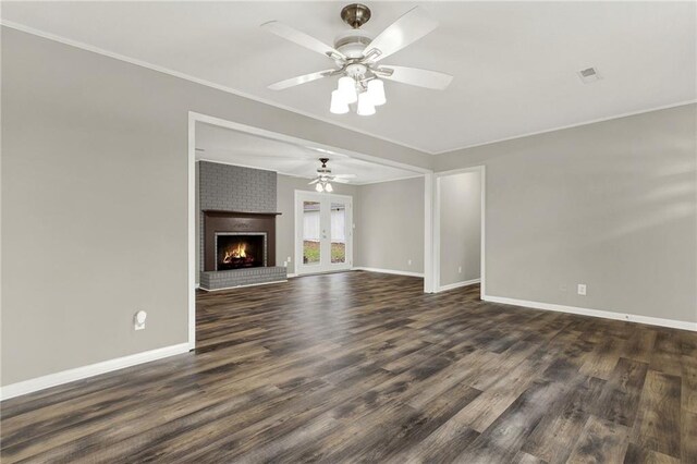 unfurnished living room with a fireplace, ceiling fan, crown molding, and dark wood-type flooring