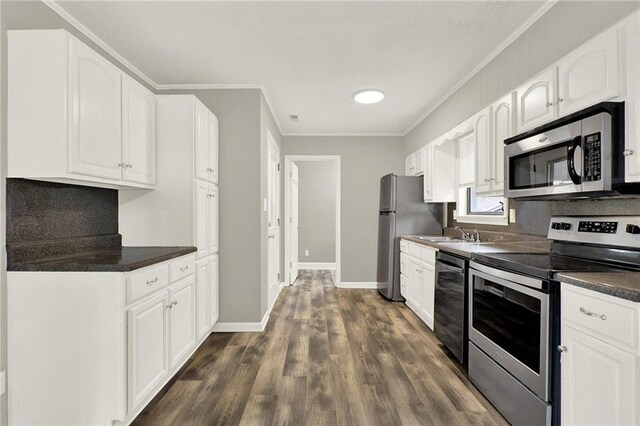 kitchen featuring appliances with stainless steel finishes, dark hardwood / wood-style flooring, crown molding, sink, and white cabinets