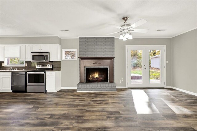 kitchen with french doors, stainless steel appliances, dark wood-type flooring, crown molding, and white cabinetry