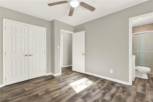 unfurnished bedroom featuring a closet, ensuite bathroom, ceiling fan, and dark wood-type flooring