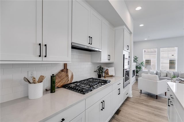 kitchen featuring white cabinets, backsplash, stainless steel gas cooktop, and light hardwood / wood-style flooring