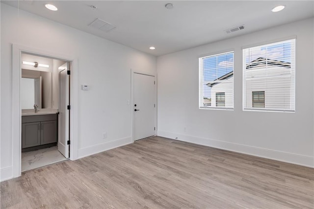 unfurnished room with light wood-type flooring and sink