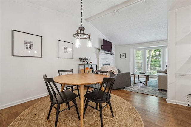 190 Windflower Trce, Roswell, GA 30075 - dining space with vaulted ceiling, a brick fireplace, wood finished floors, crown molding, and a chandelier