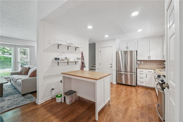 190 Windflower Trce, Roswell, GA 30075 - kitchen featuring freestanding refrigerator, stove, white cabinets, light wood-style flooring, and a textured ceiling