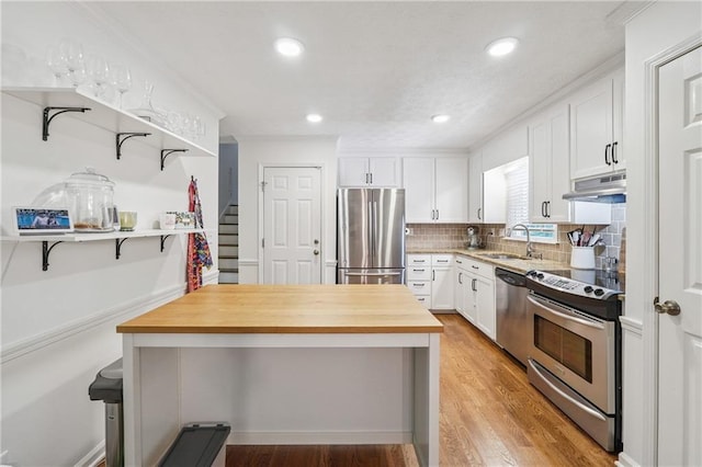 190 Windflower Trce, Roswell, GA 30075 - kitchen with stainless steel appliances, butcher block counters, under cabinet range hood, open shelves, and white cabinets