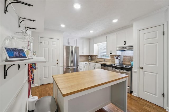 190 Windflower Trce, Roswell, GA 30075 - kitchen featuring appliances with stainless steel finishes, under cabinet range hood, butcher block countertops, tasteful backsplash, and recessed lighting
