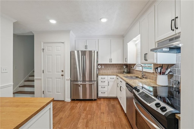 190 Windflower Trce, Roswell, GA 30075 - kitchen with appliances with stainless steel finishes, under cabinet range hood, white cabinetry, decorative backsplash, and recessed lighting