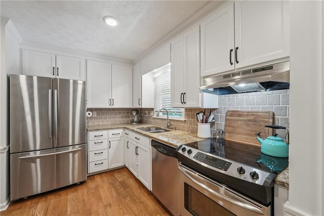 190 Windflower Trce, Roswell, GA 30075 - kitchen featuring appliances with stainless steel finishes, under cabinet range hood, white cabinets, light wood-style flooring, and light stone counters