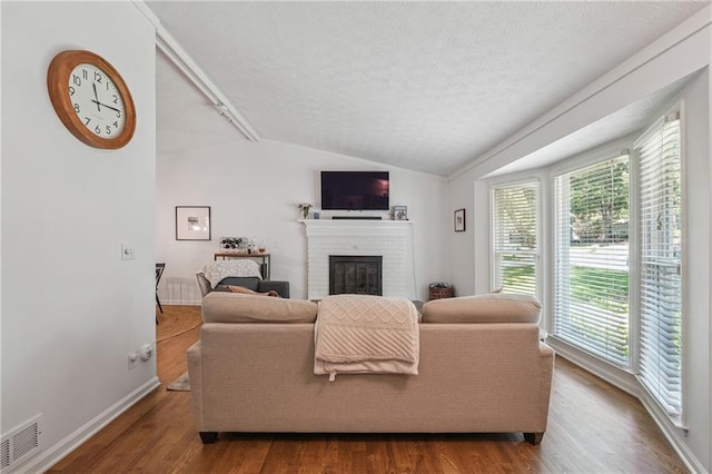 190 Windflower Trce, Roswell, GA 30075 - living area with a brick fireplace, wood finished floors, a textured ceiling, and lofted ceiling