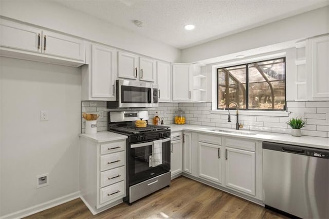 kitchen featuring stainless steel appliances, white cabinets, a sink, and open shelves