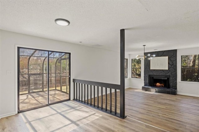 interior space featuring a large fireplace, wood finished floors, and a healthy amount of sunlight