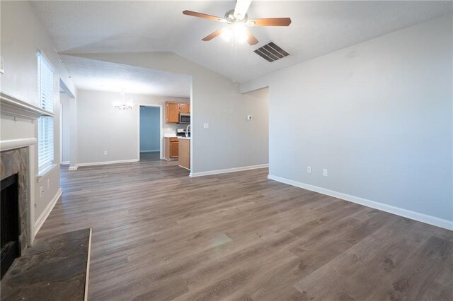 unfurnished living room featuring vaulted ceiling, ceiling fan with notable chandelier, and dark hardwood / wood-style flooring