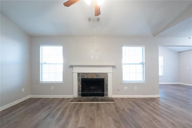 unfurnished living room with lofted ceiling, hardwood / wood-style flooring, a fireplace, and a healthy amount of sunlight