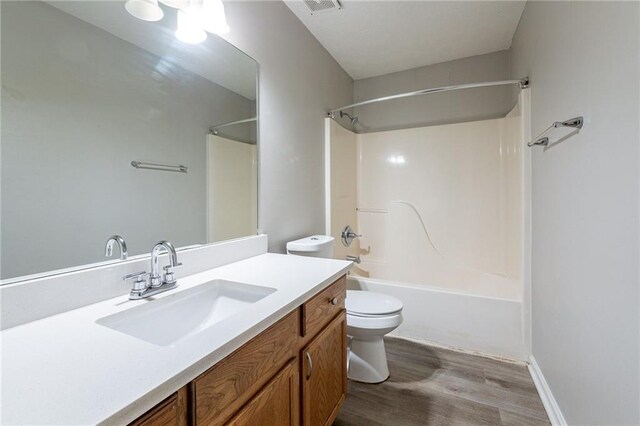 full bathroom featuring vanity, hardwood / wood-style flooring, shower / washtub combination, and toilet