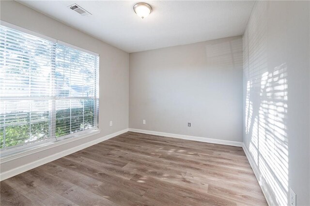 spare room with hardwood / wood-style floors and a wealth of natural light