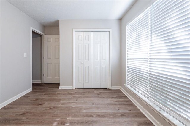 unfurnished bedroom with light hardwood / wood-style floors and a closet