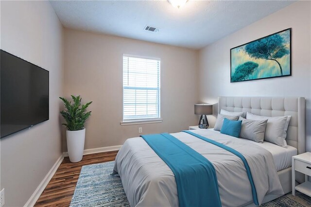 bedroom with dark hardwood / wood-style flooring