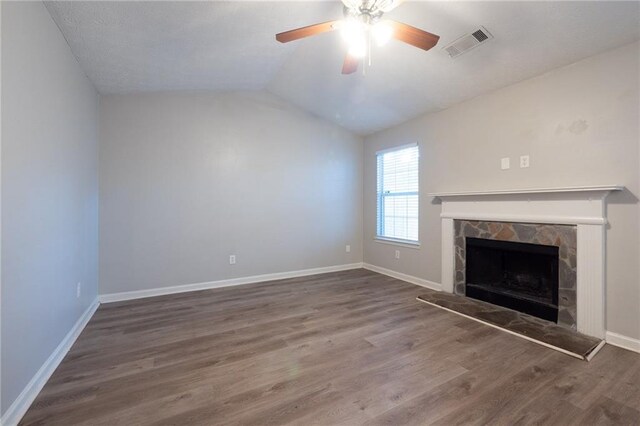 unfurnished living room with dark wood-type flooring, ceiling fan, lofted ceiling, and a fireplace