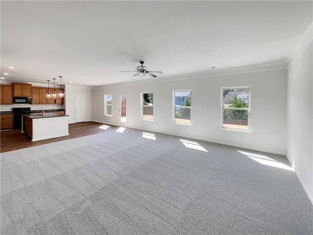 unfurnished living room featuring dark colored carpet, recessed lighting, baseboards, and ornamental molding